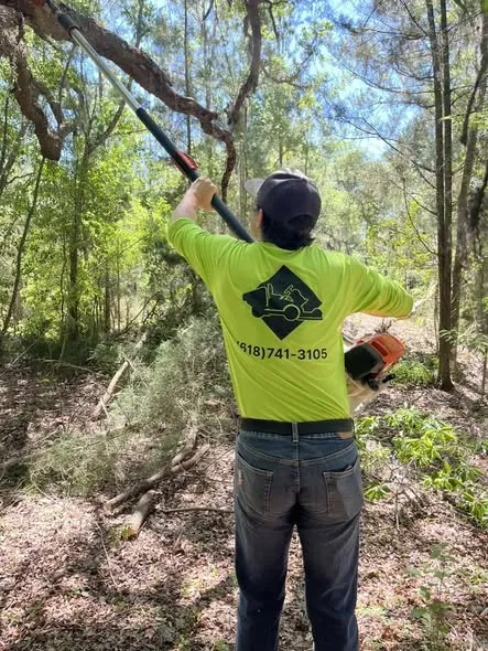 Pole-saw trimming in a Ton's Ag crew shirt